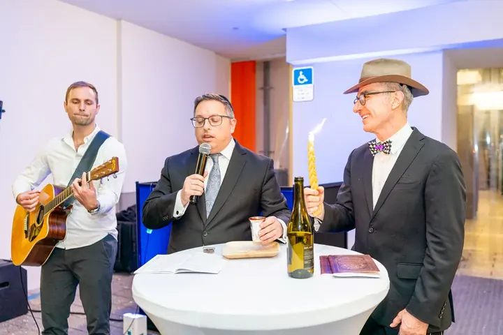 Havdalah ceremony at the conference with a guitarist, Havdalah candle, and wine bottle