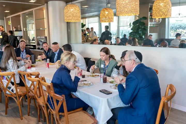 Attendees enjoying a glatt kosher lunch together at a restaurant-style dining table